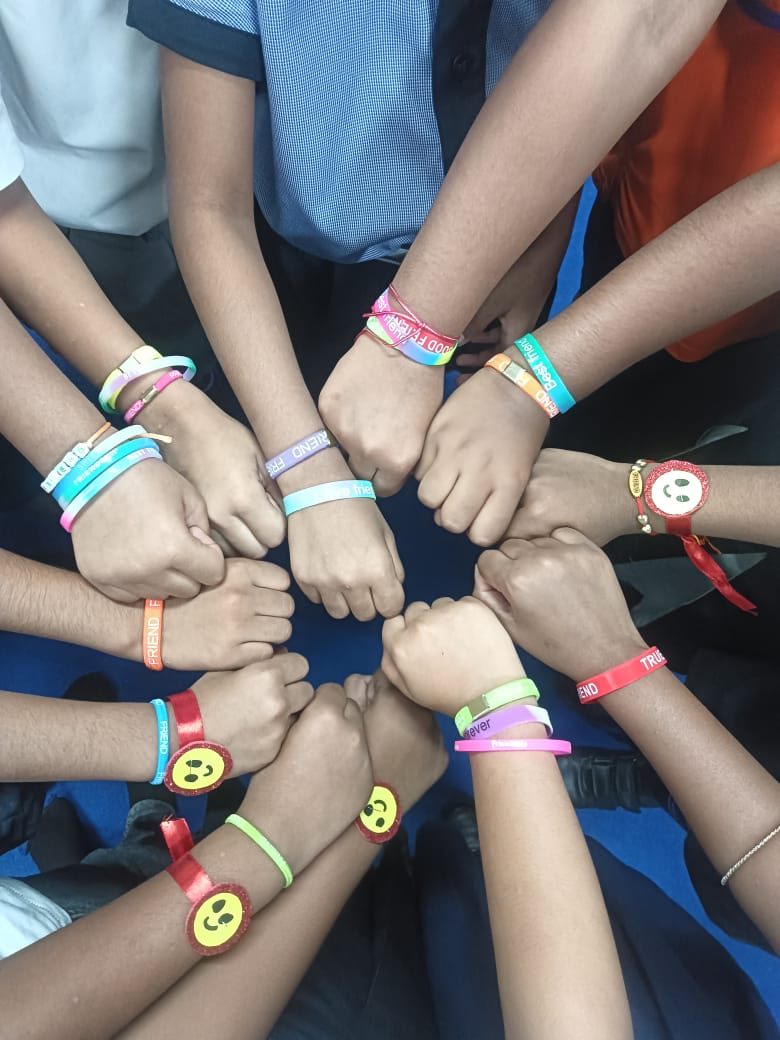 Children and adults showing friendship bands on their wrists